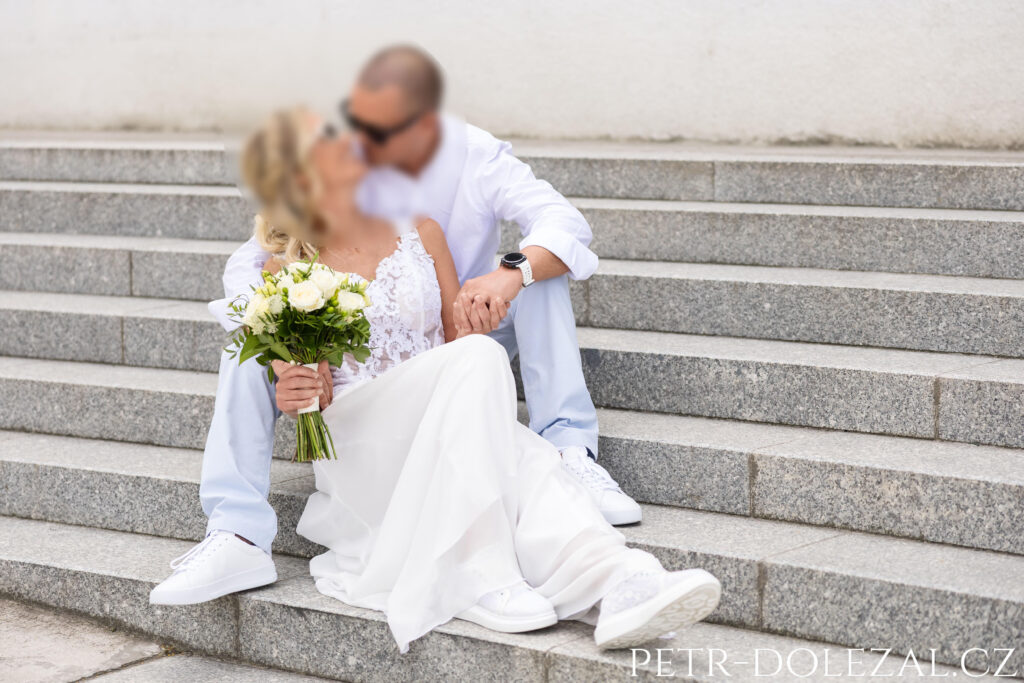 Ženich a nevěsta sedící na schodišti