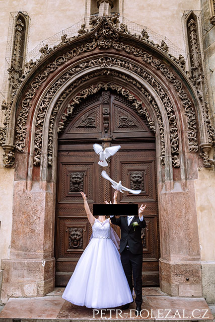 bride and groom releasing doves in front of historical door
