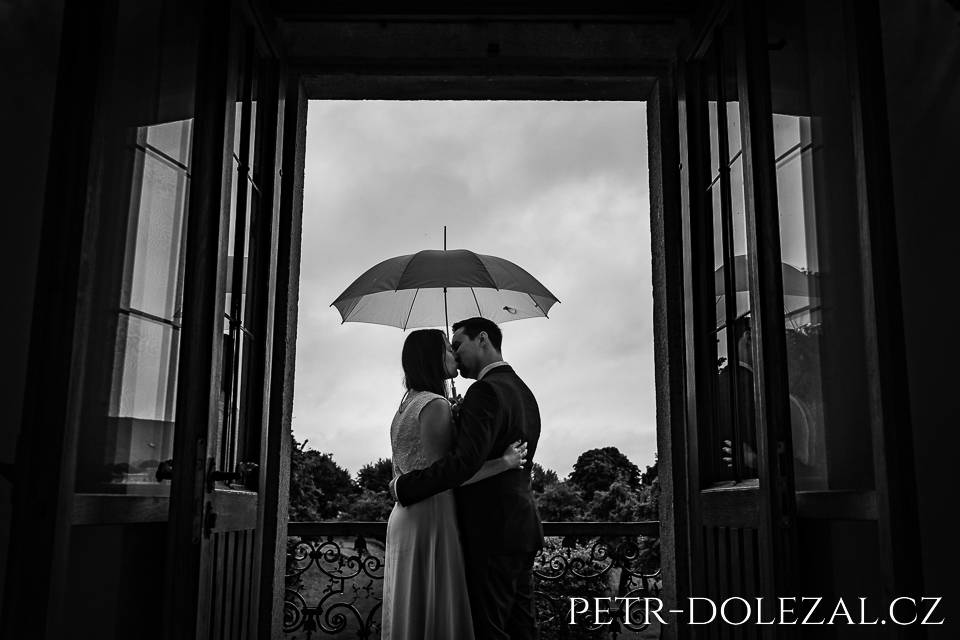 Bride and groom during rainy wedding day in pavilion Vojteska