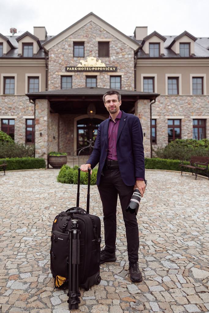 Svatební fotograf Petr Doležal s fotoparátem, kufrem a stativem před Park Hotelem Popovičky