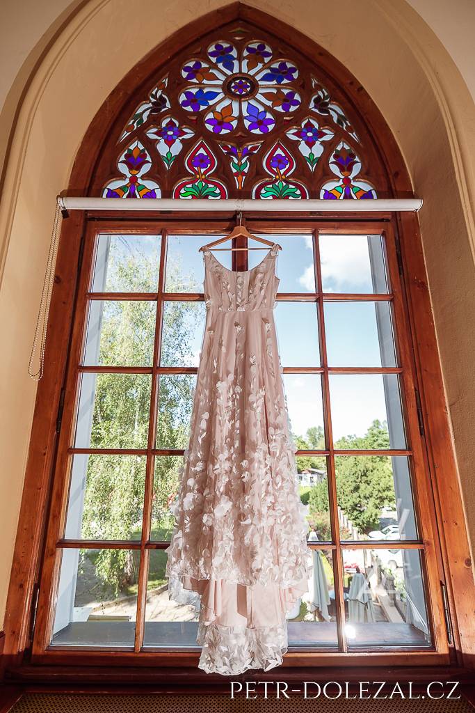 Šaty nevěsty zavěšené v kapli hotelu St. Havel