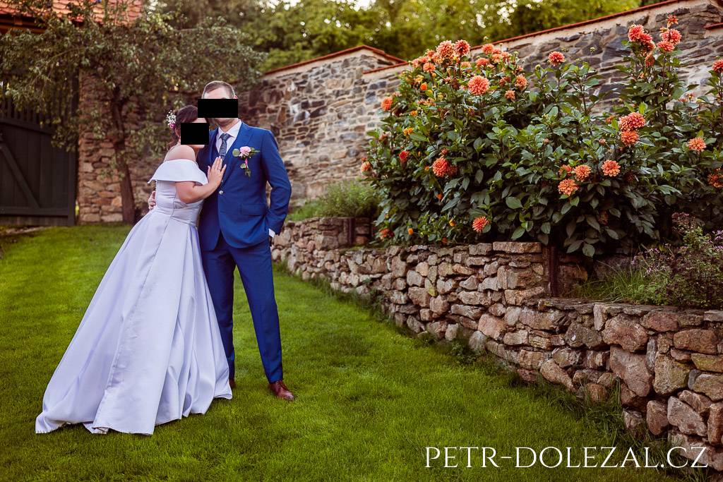 Novomanželé stojící na zahradě hotelu Všetice u květin
