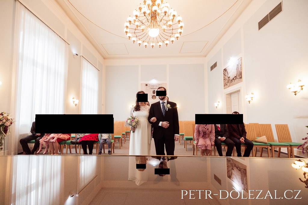 Svatební obřad ve Vysočanské radnici, ve stole se zrcadlí hlavy nevěsty a ženicha