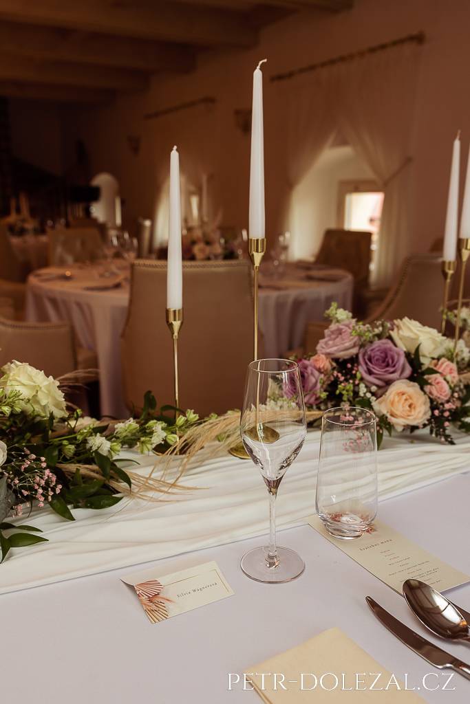 Svíce na stolech svatební hostiny v zámku Trnová