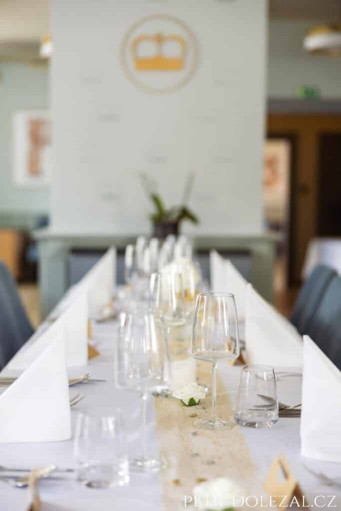 Detail se sklenicemi na svatební tabuli uvnitř restaurace