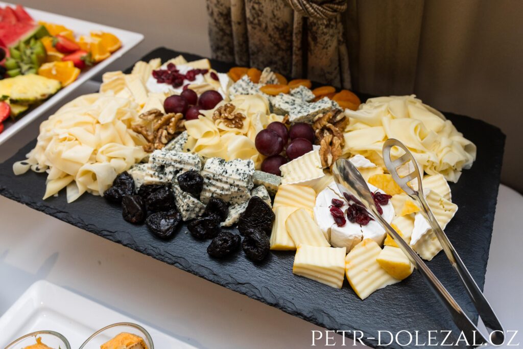 rozmanité druhy sýra servírované na břidlicovém podnosu