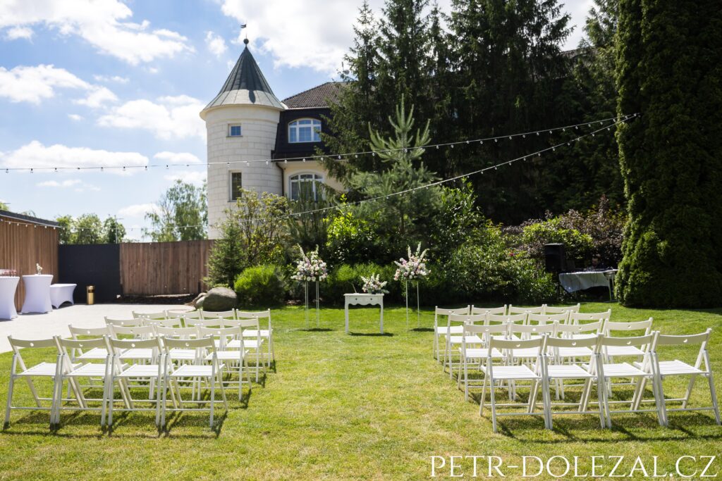 židle, květiny a hlavní pultík připravené pro svatební obřad