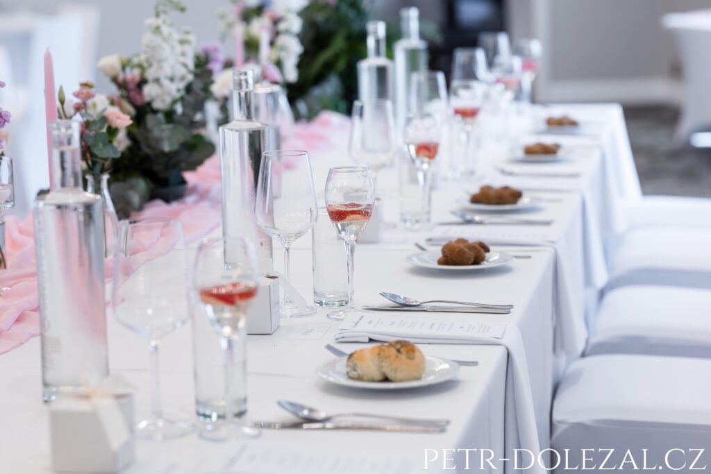 řada sklenic a talířů na svatební tabuli