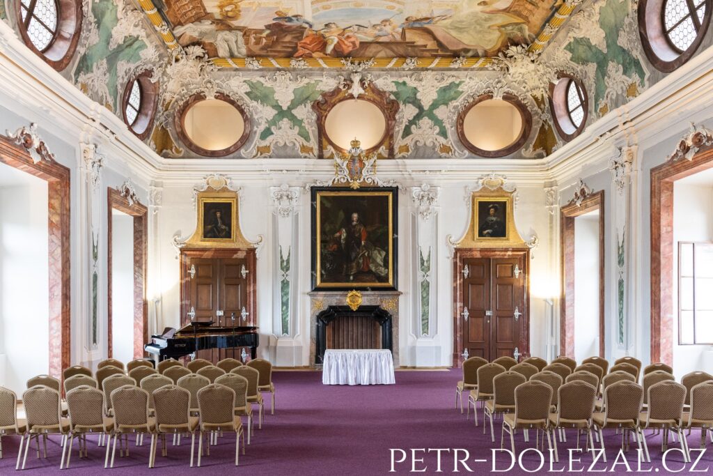 Jižní strana Tereziánského sálu se židlemi a klavírním křídlem