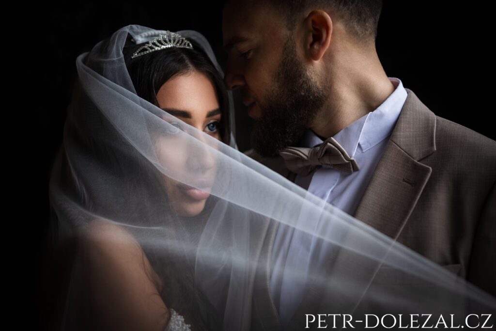 Low-key dvojportrét ženicha a nevěsty se závojem
