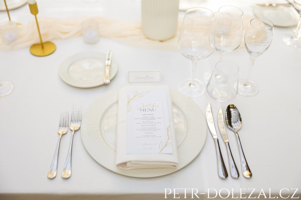 Svatební menu na talíři prostřeného stolu pro svatební hostinu