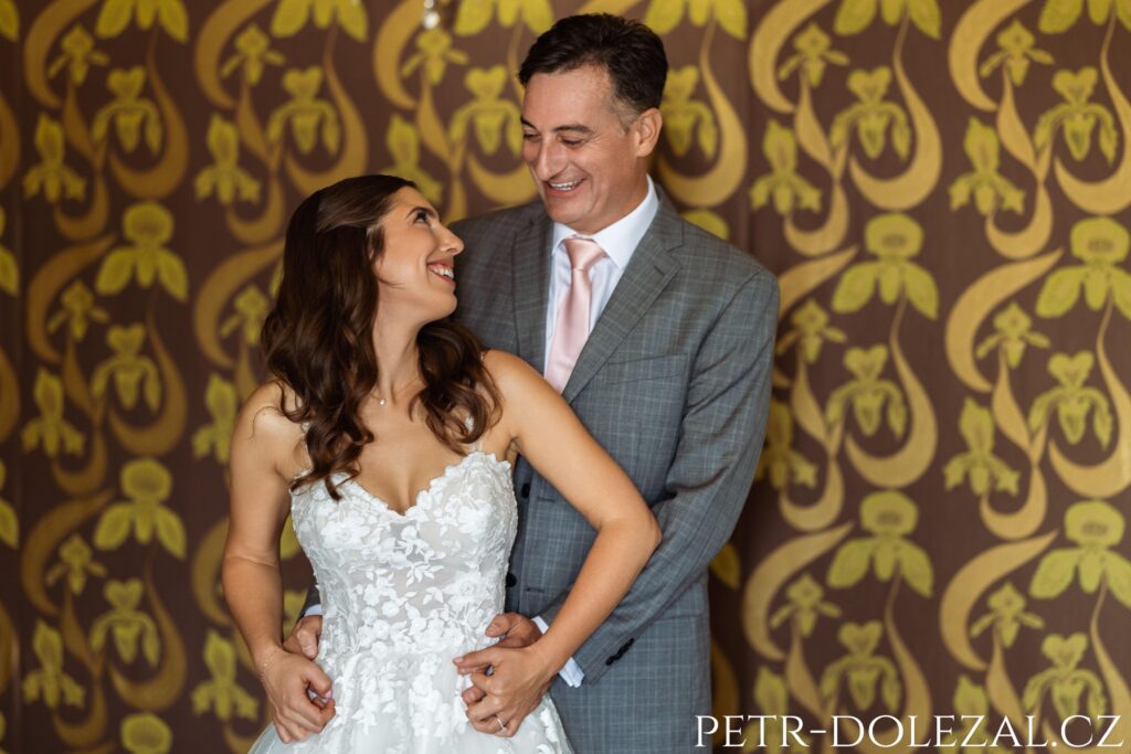 Interiérový portrét smějící se nevěsty a ženicha