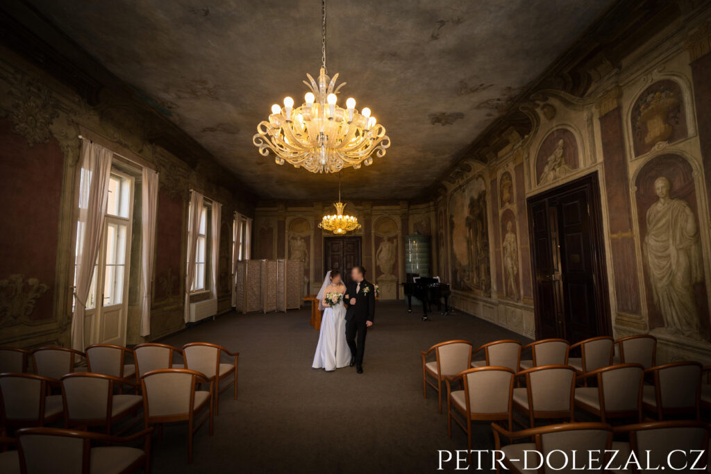 Novomanželé kráčející v obřadní síni